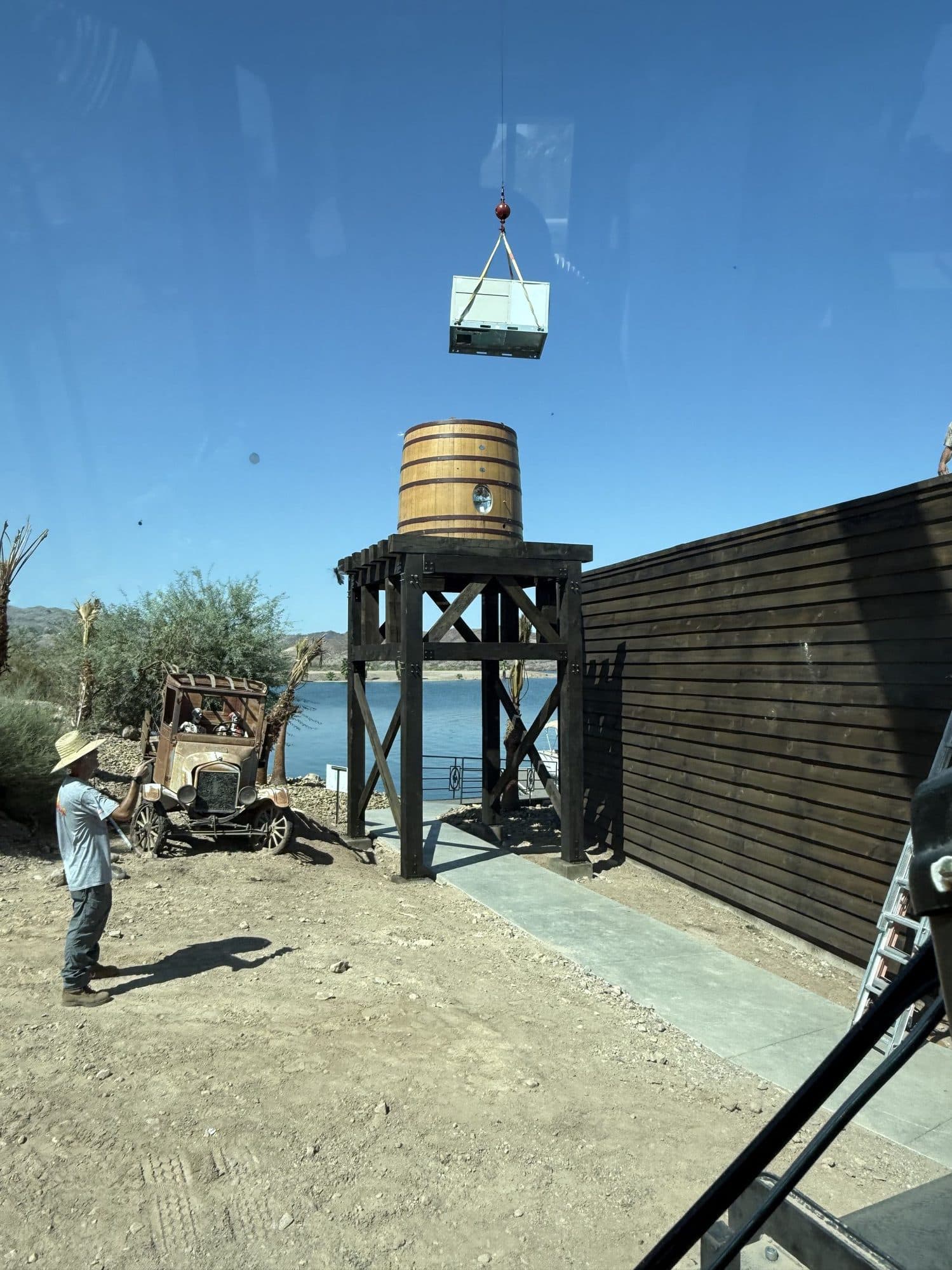 View from the crane cab of a suspended unit above a wooden water tower with the lake behind